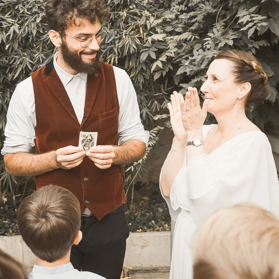 Magicien mariage Metz réalisant un tour de cartes à une mariée qui applaudit