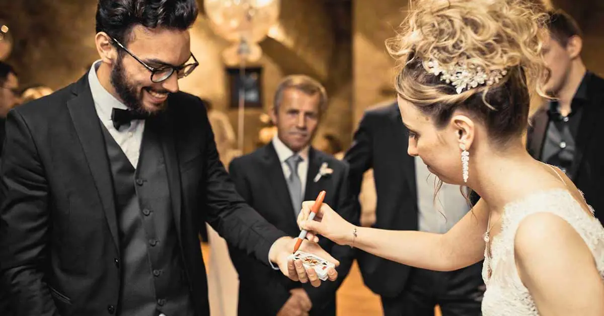 Sebastien Pieta, le magicien, fait un spectacle de magie dans un mariage à Paris. La mariée signe une carte durant un tour de magie.
